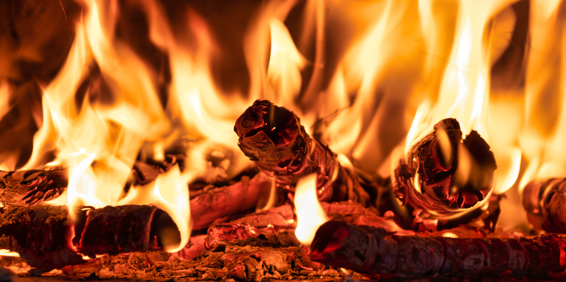 Glowing embers and flames inside a traditional wood-fired oven